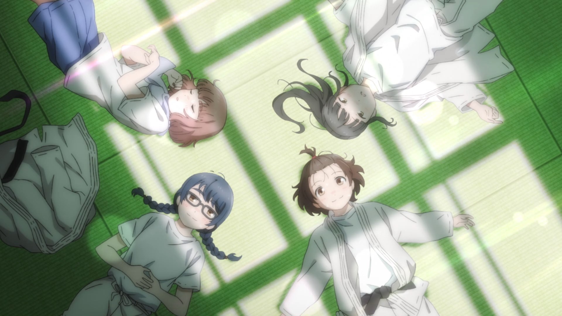 The four main characters lying in a circle on the tatami mats in judo and sports gear
